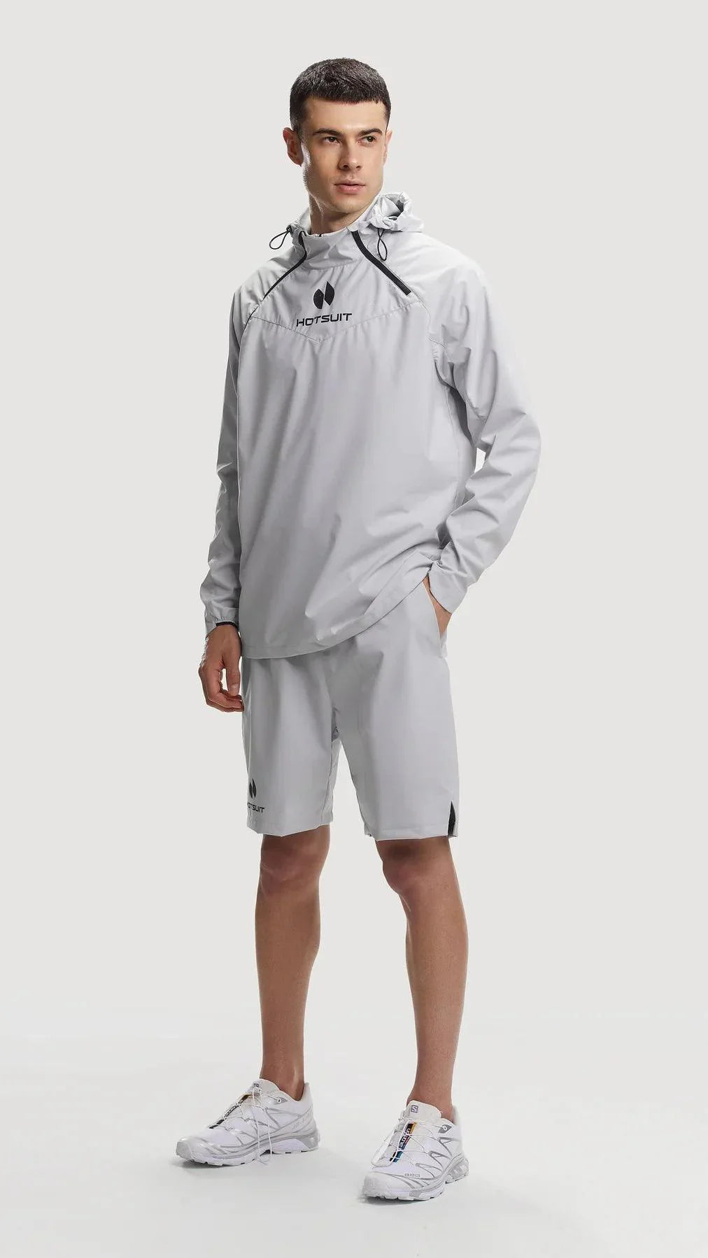 Man wearing gray HOTSUIT sauna suit with hood and matching shorts, fitness apparel